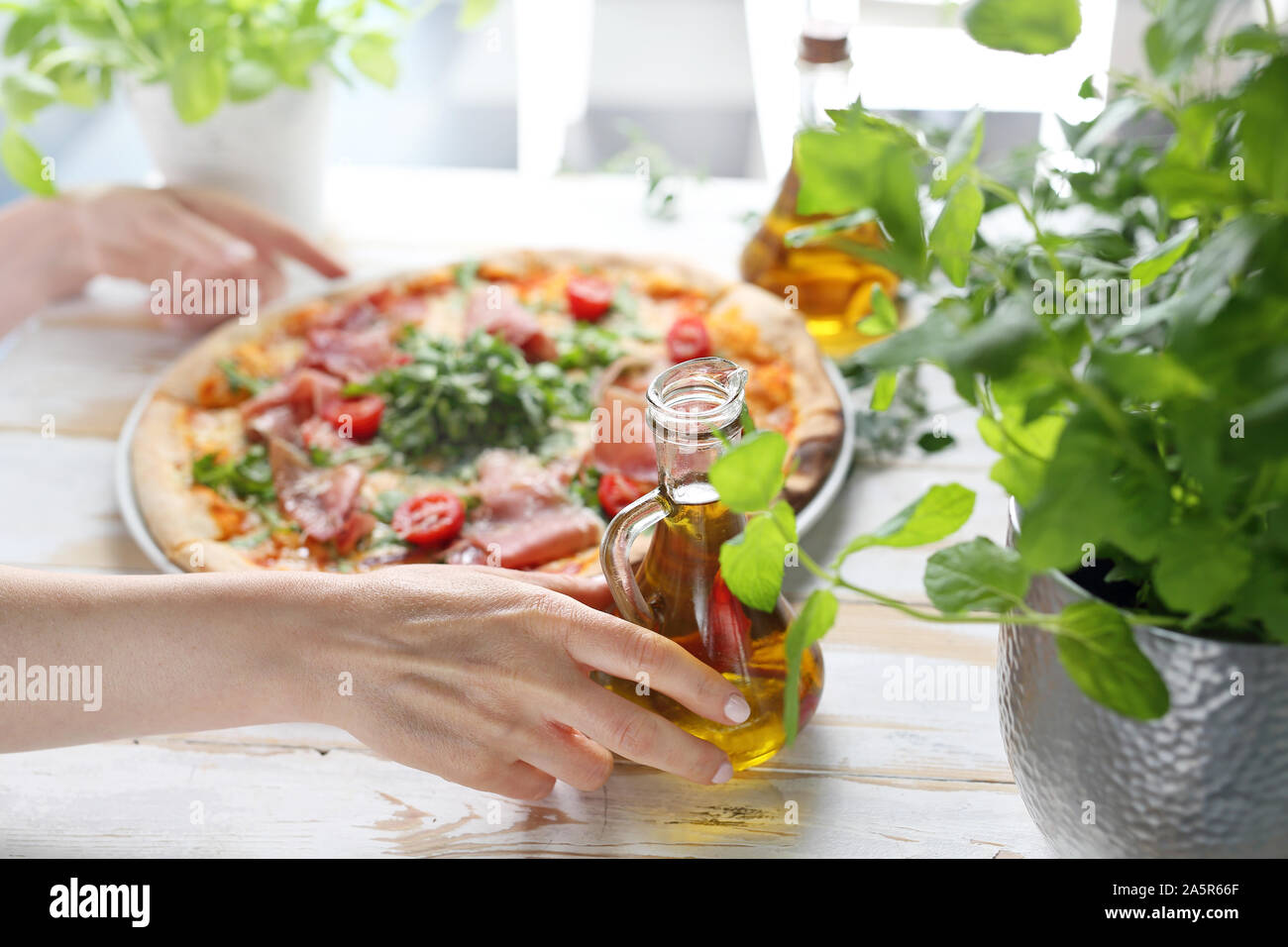 Pizza tradizionale pizza italiana su una sottile pasta croccante con prosciutto di Parma, i pomodori e il verde insalata di rucola. Foto Stock