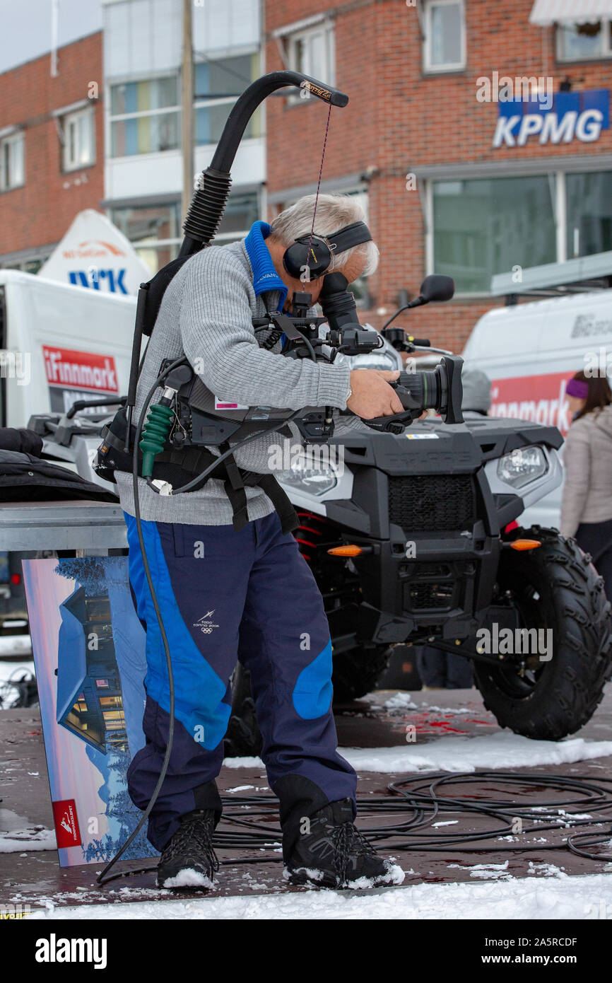 Finnmark, Norvegia - Marzo 15, 2019: riprese video del Finnmarkslopet slitta trainata da cani multi-giorni di gara. Operatore al lavoro. Foto Stock