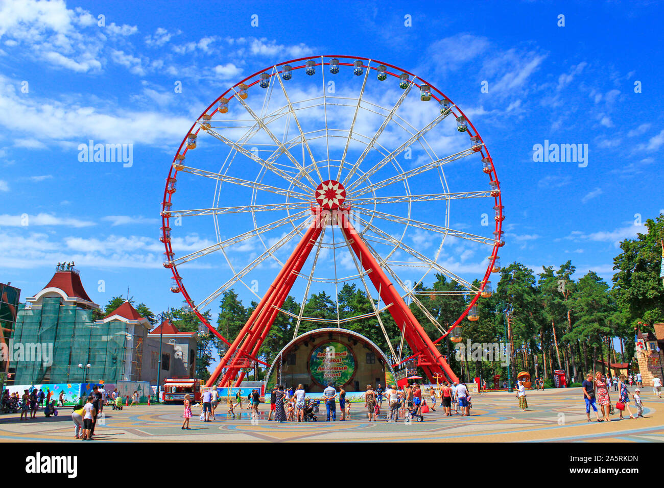 Fferris ruota e la gente a piedi in Gorky Park in Kharkiv. La gente camminare nel parco cittadino con intrattenimenti. Le persone hanno un riposo nel parco della città Foto Stock