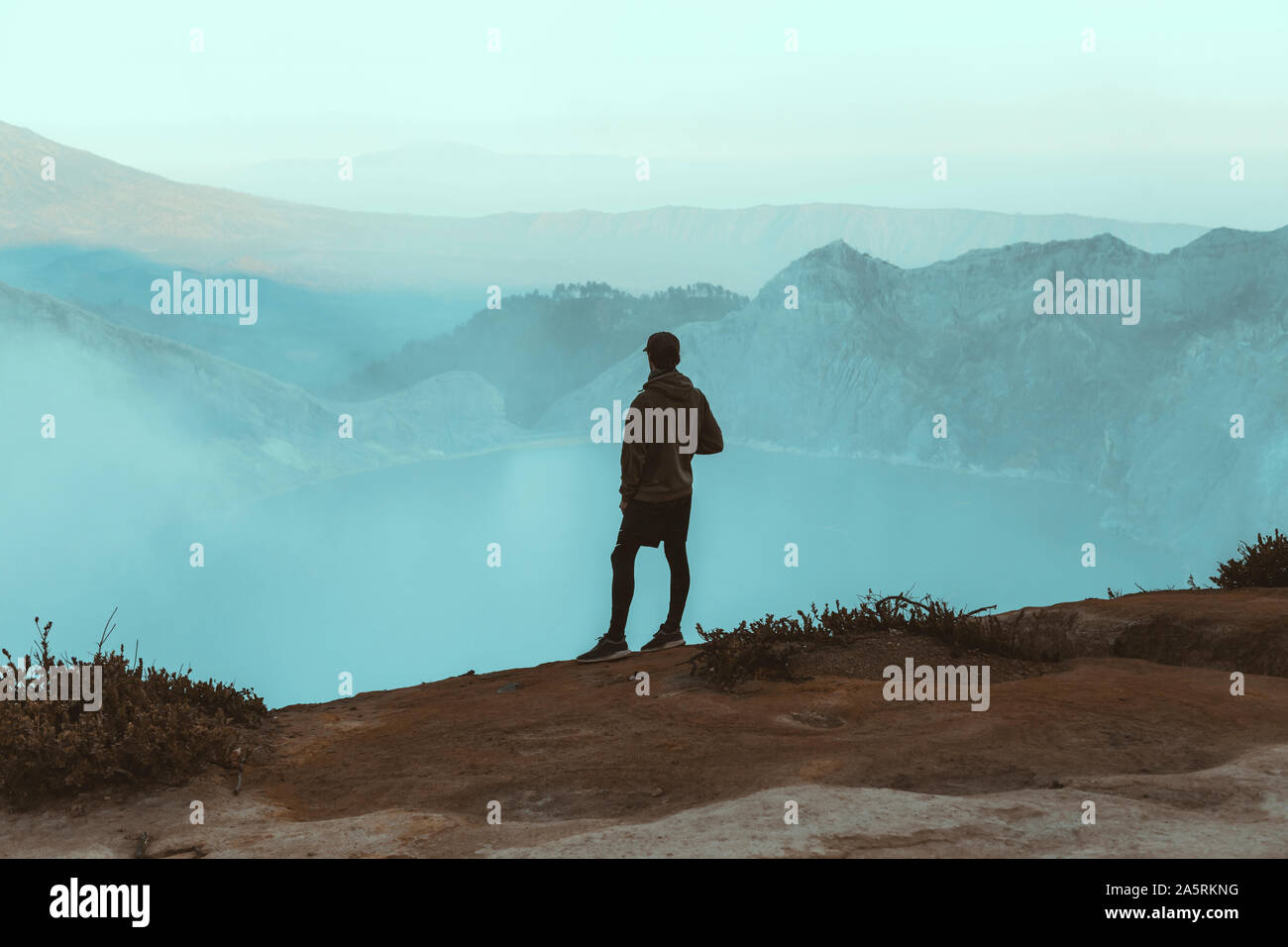 Giovane uomo che guarda al lago Ijen Foto Stock