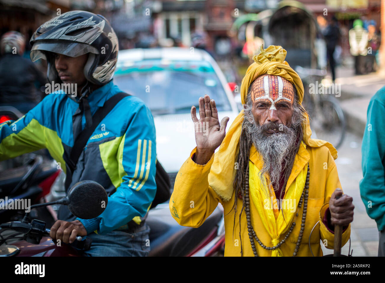 Un sadhu, un Indù uomo santo, pause in una strada a Kathmandu, Nepal Foto Stock