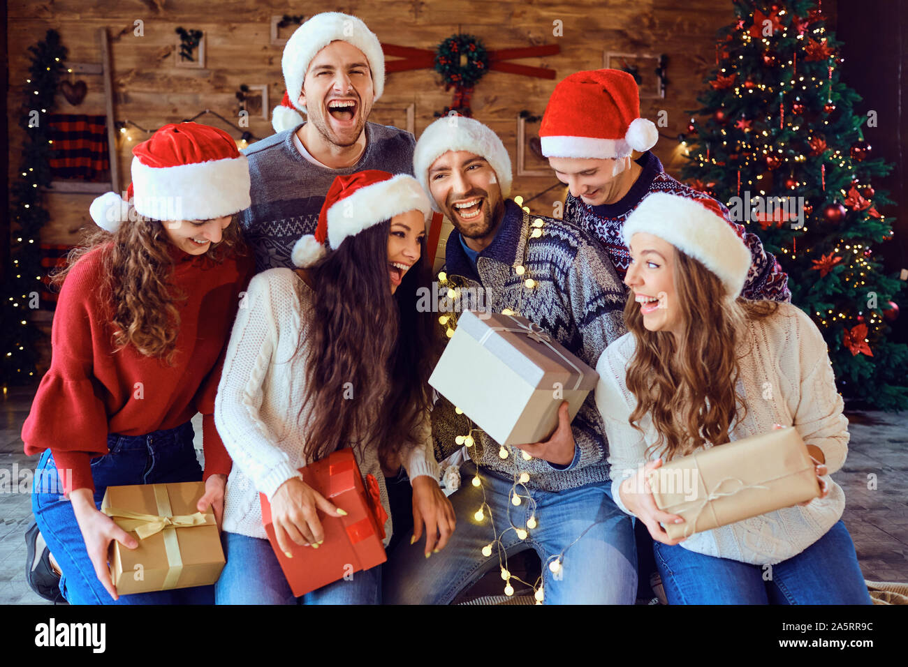 Bella giovane donna che festeggia il natale a casa, con divertenti regali  di apertura Foto stock - Alamy