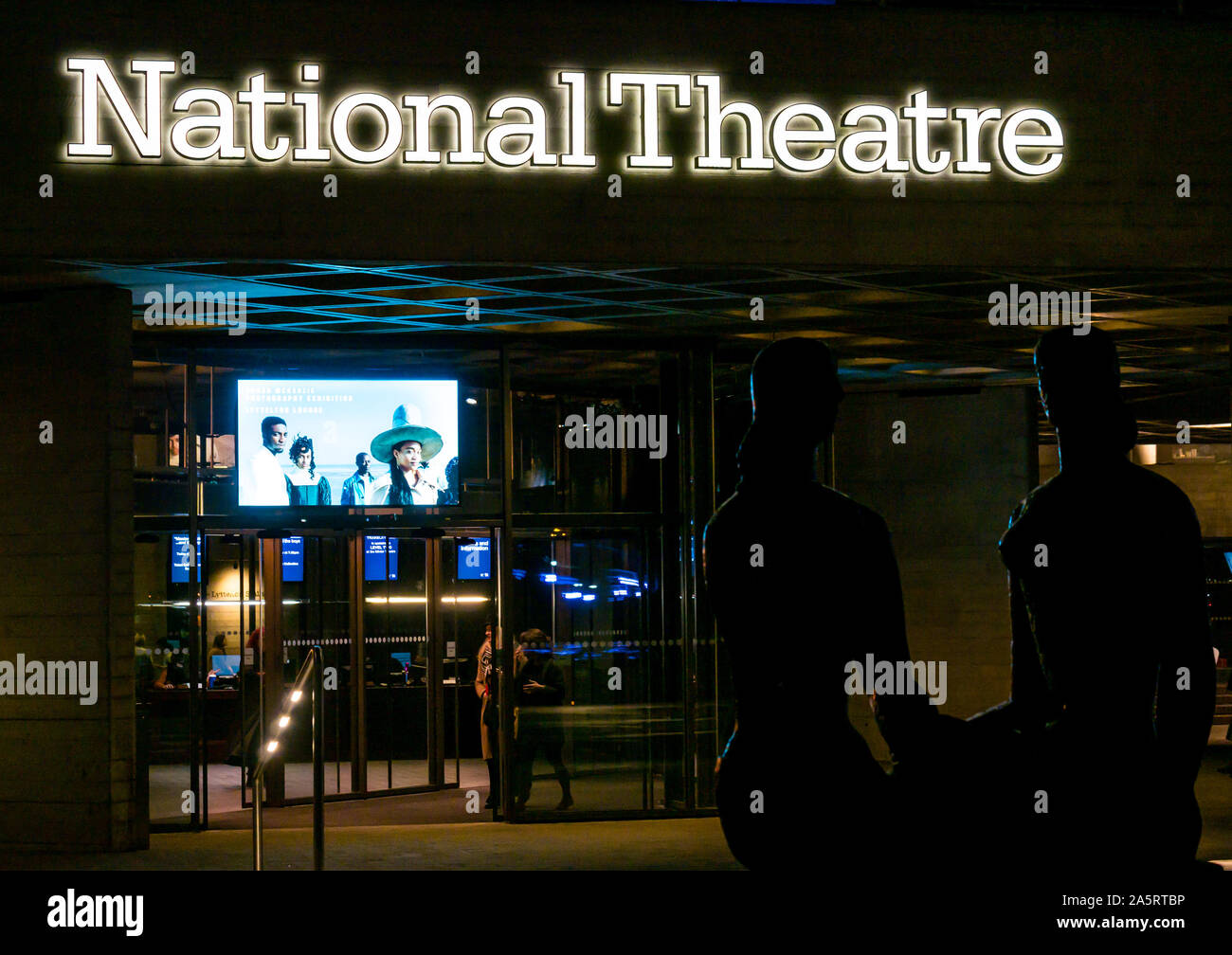 Teatro Nazionale di notte con silhouette di Frank Dobson scultura orgoglio di Londra, South Bank di Londra, England, Regno Unito Foto Stock