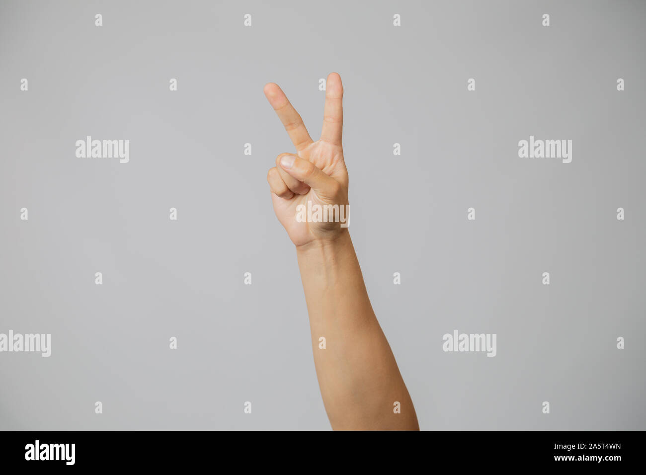 Mostrando la mano con le dita in studio con sfondo grigio... Foto Stock
