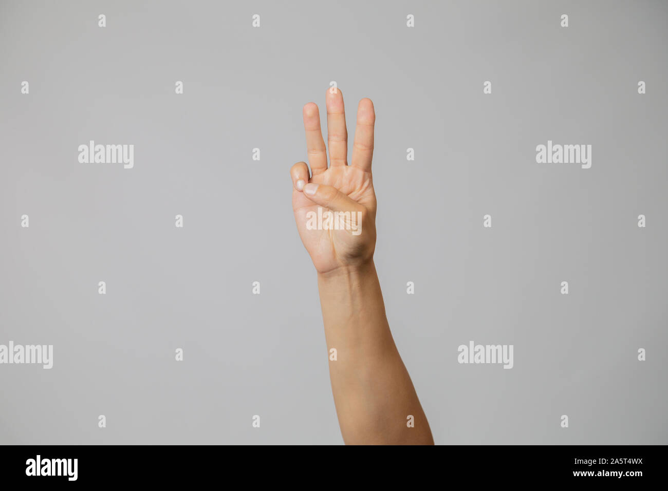 Mostrando la mano con le dita in studio con sfondo grigio... Foto Stock
