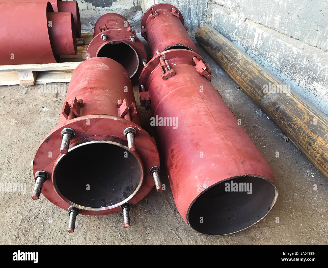 Premistoppa rosso di giunti di dilatazione per principale di riscaldamento sul pavimento di cemento. Il calore e la nozione di potenza. Foto Stock