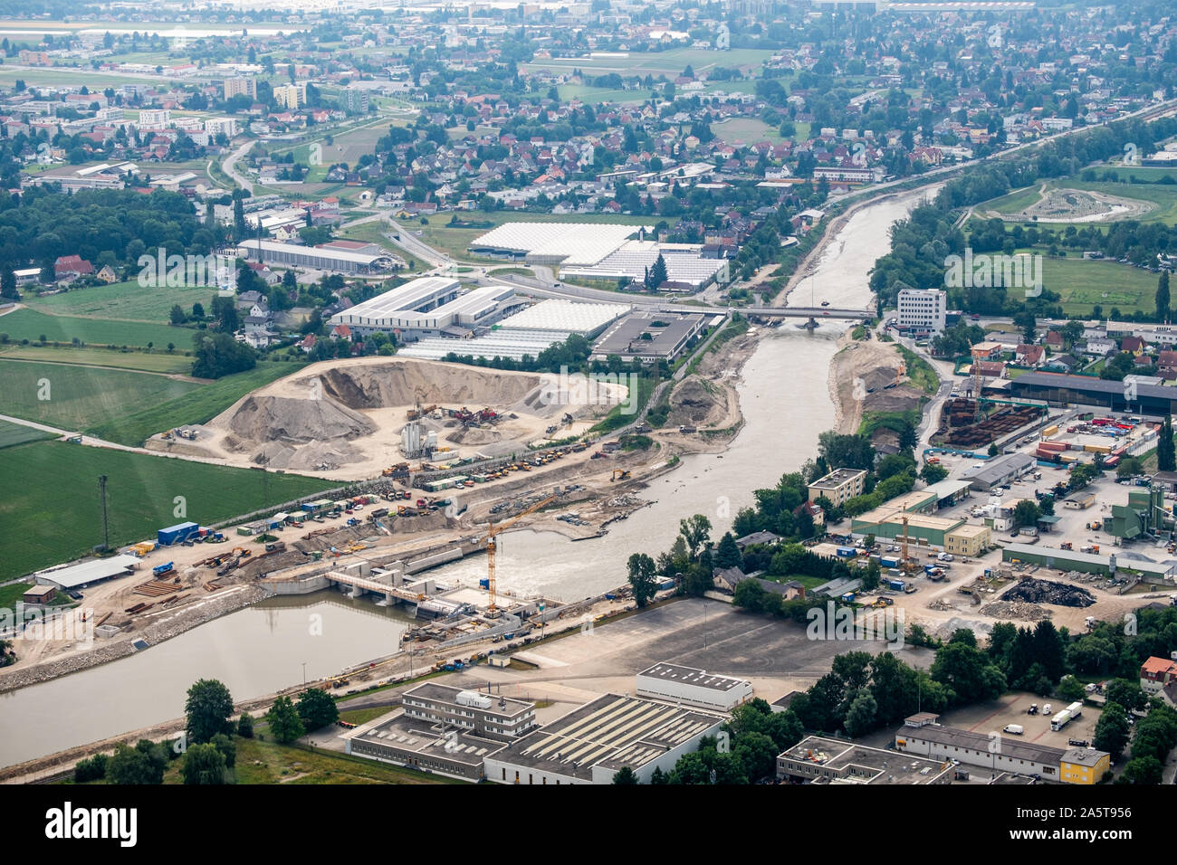 Vista aerea dell'edificio di costruzione di impianti nel fiume Mur della città di Graz da elicottero drone con il distretto Liebenau su un nuvoloso giorno di estate in Australia Foto Stock