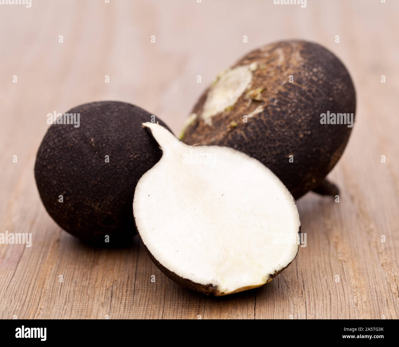 Rafano nero su sfondo di legno Foto Stock