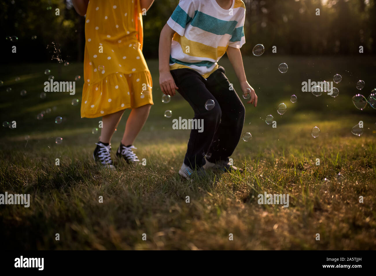 I fratelli jumping in bolle nella luce dorata e anonimi Foto Stock