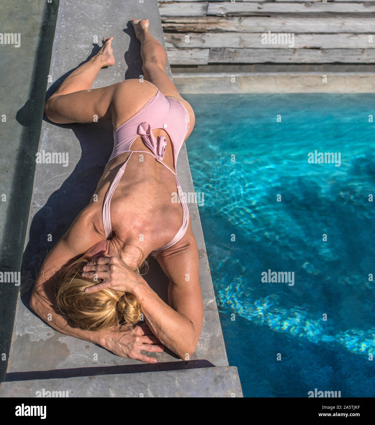 La donna posa da piscina relax in costume da bagno Foto Stock