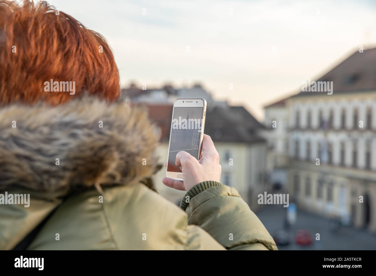 Una donna sta guardando a Brno da una visualizzazione di terrazza. Scattare foto della città sul telefono e condividerle sul sito sociale Foto Stock