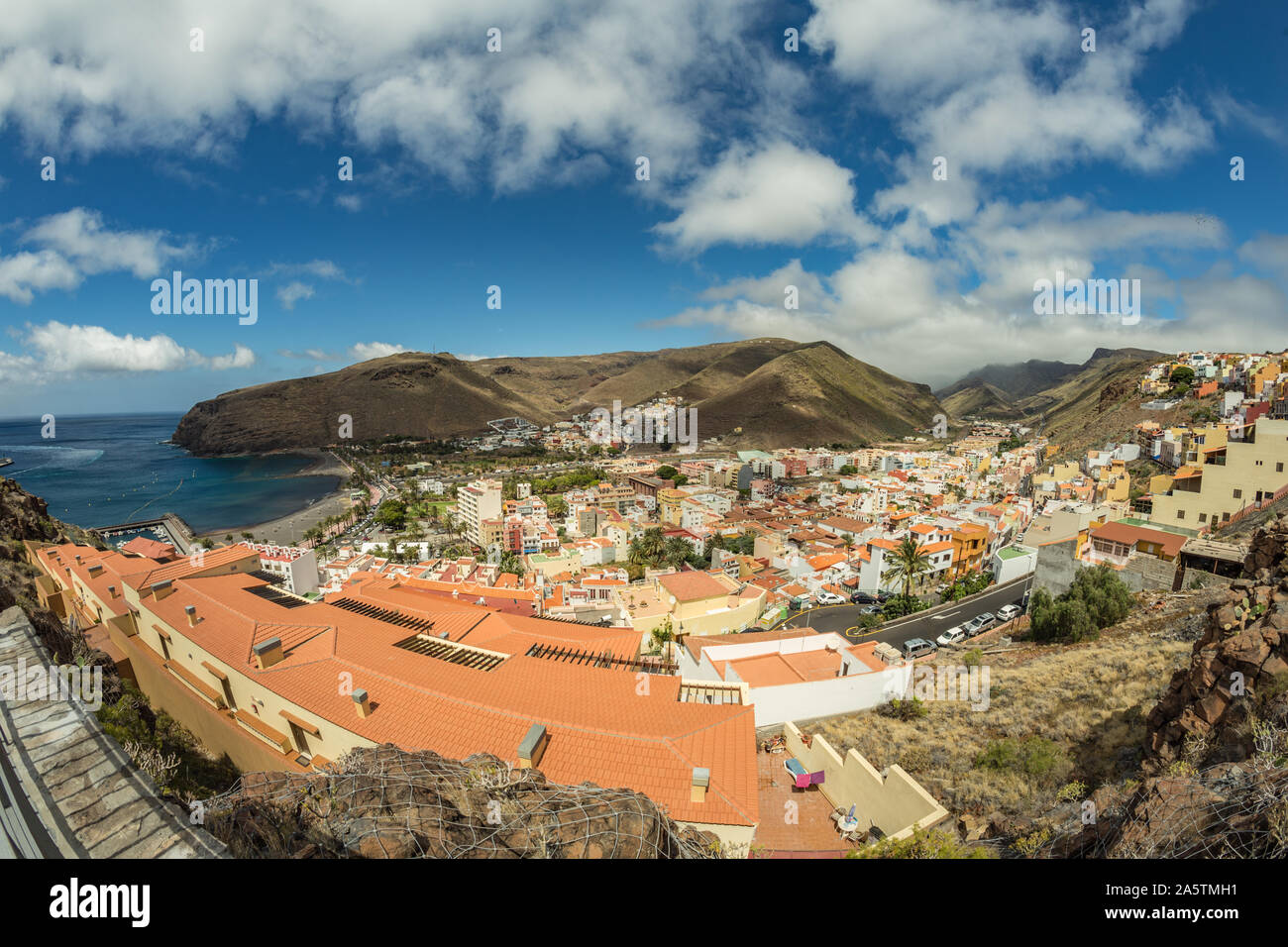 Vista aerea dalla montagna per il porto principale dell'isola di La Gomera. Tetti colorati e case sul pendio del Vulcano di San Sebastian de la Gomera, S Foto Stock