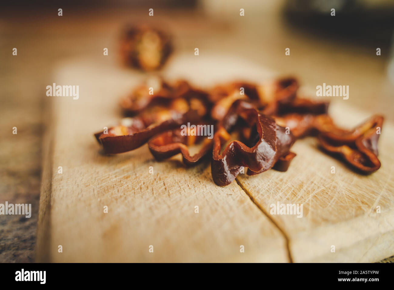 Il cioccolato Habanero Peperoncino (Capsicum chinense) le fette su un legno tagliere. Una sana e davvero Hot Chili Peppers. Sfondo sfocato. Foto Stock