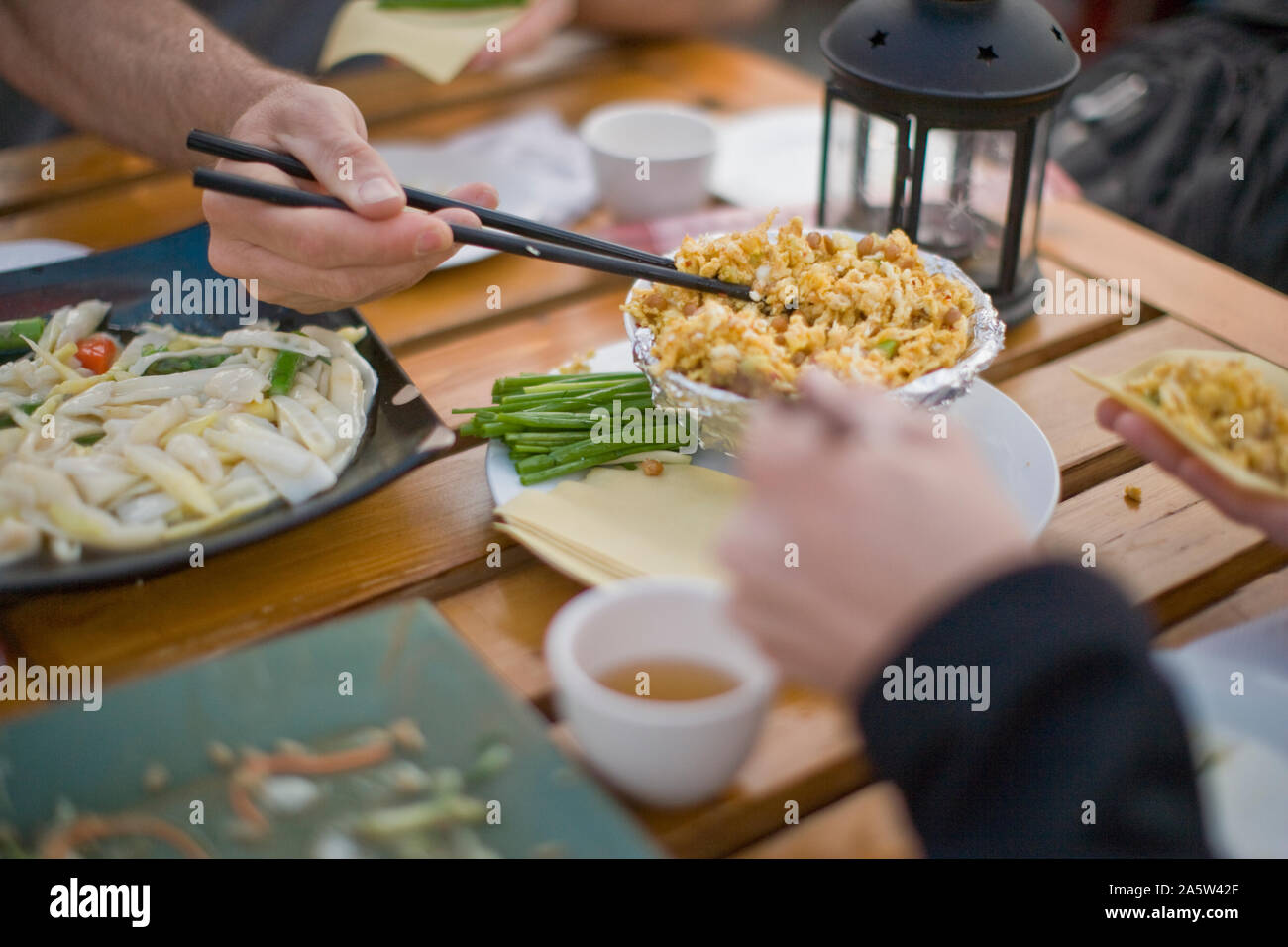 Bacchette di prelevare il cibo sulla tavola imbandita di un ristorante. Foto Stock