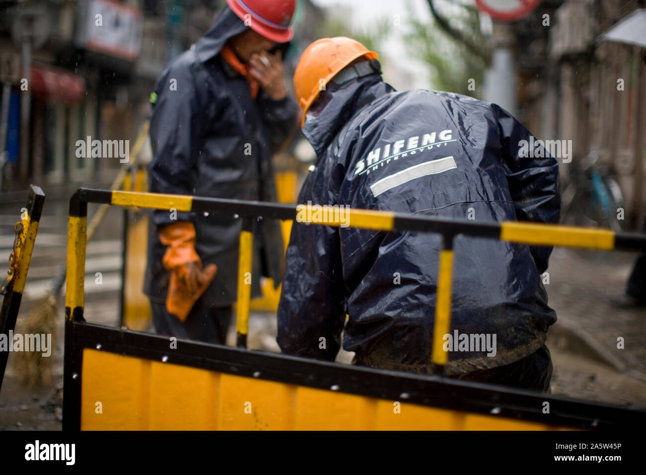 Due lavoratori edili al lavoro. Foto Stock