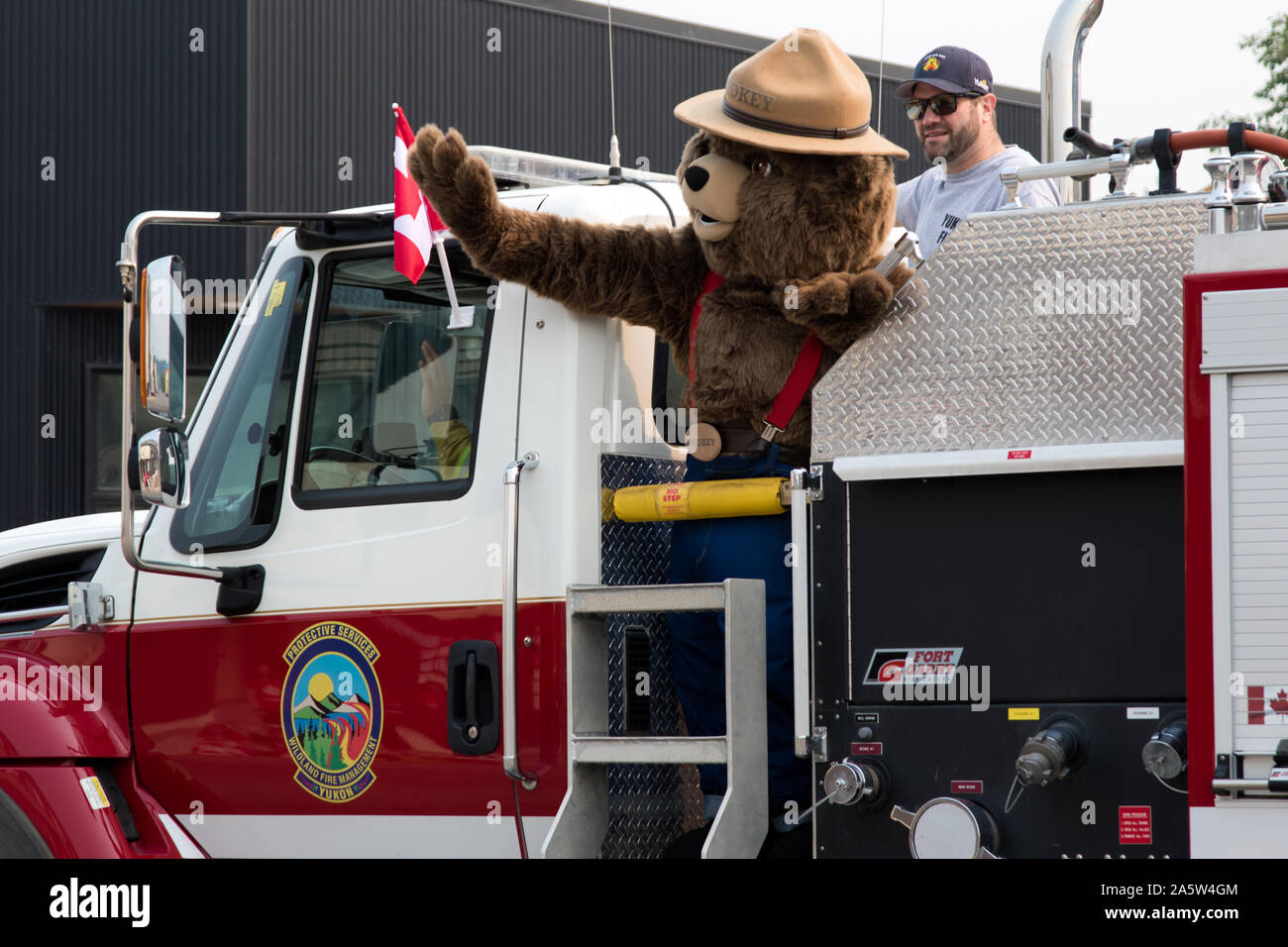 Smokey Bear equitazione in un camion dei pompieri prendendo parte al 2019 luglio 01 Canada giorno parata tenutasi a Whitehorse, Yukon, Canada. Una festività nazionale. Foto Stock