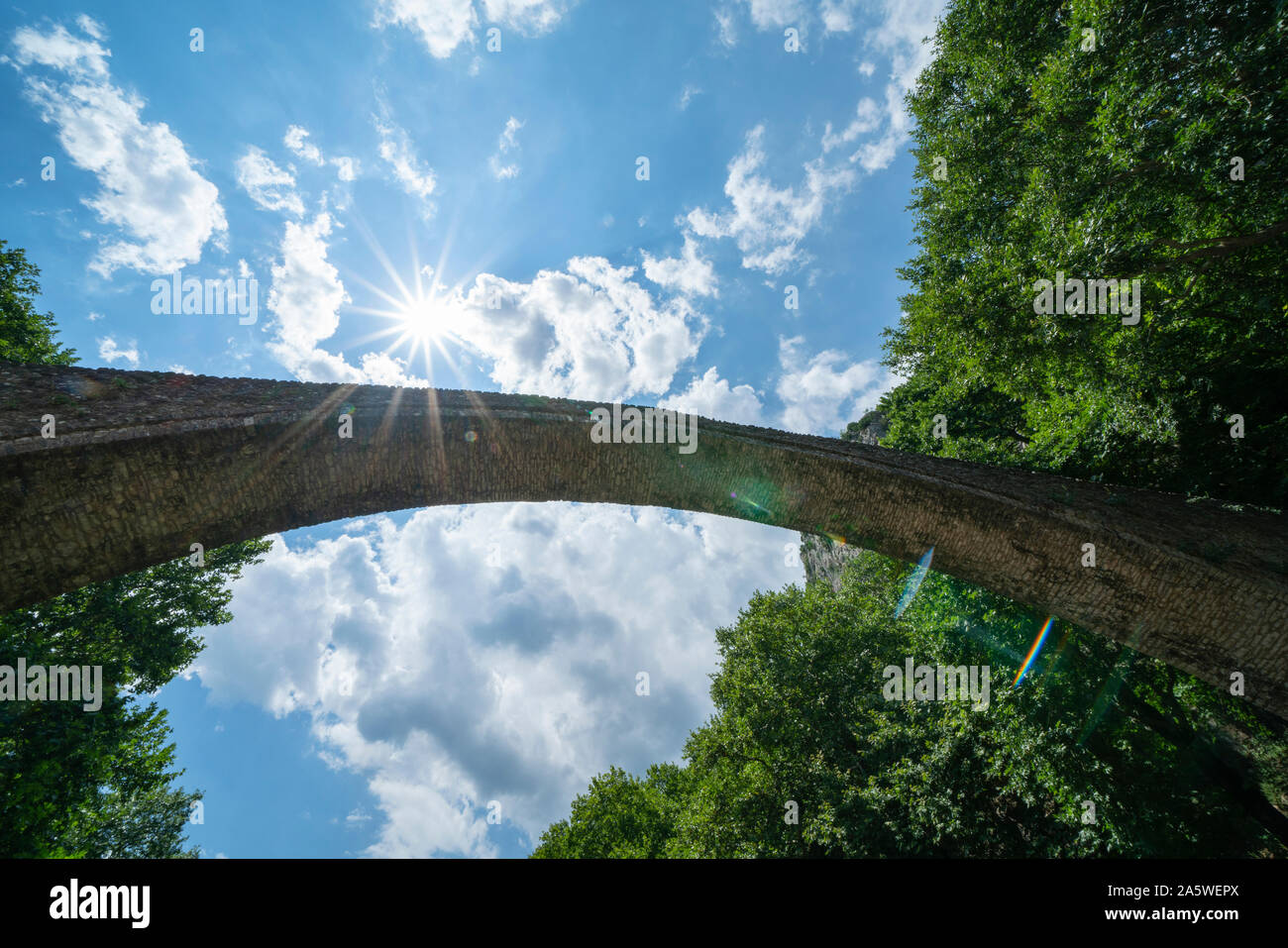 Al di sotto di pietra storica unica arcata del ponte pedonale alla ricerca fino al cielo a Zagori in montagne in Grecia centrale. Foto Stock