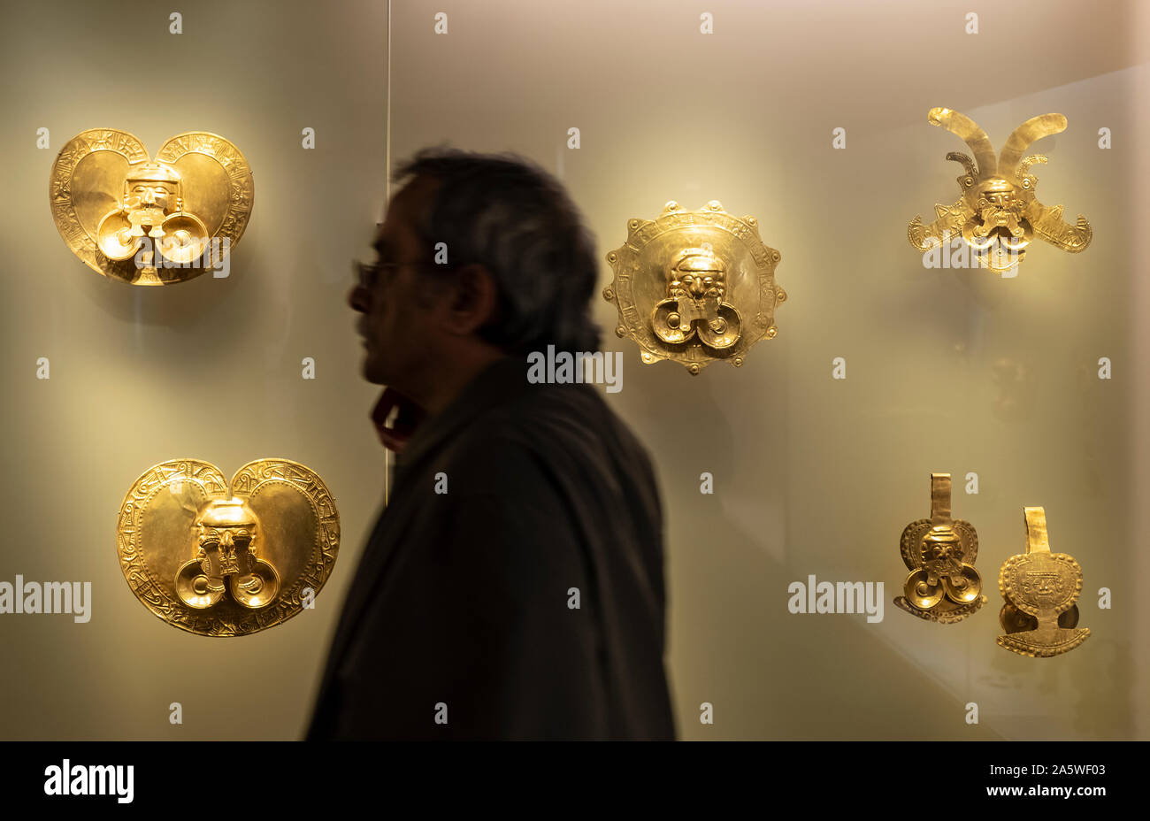 Visitatore infront dei pettorali, precolombiana goldwork raccolta, Museo dell'oro, Museo del Oro, Bogotà, Colombia, America Foto Stock