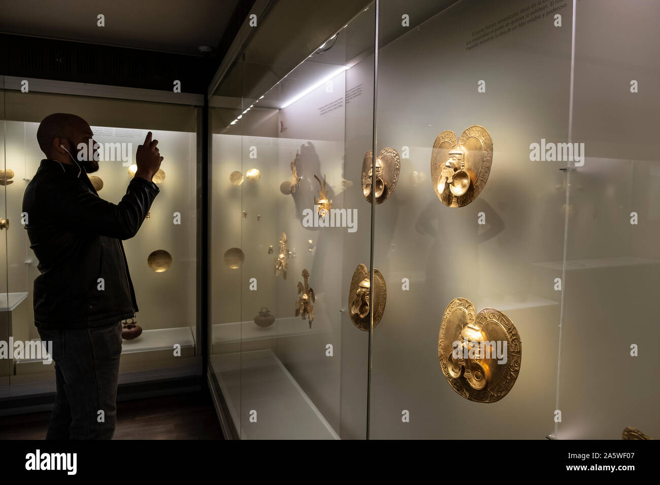 Visitatore osservando pettorali, precolombiana goldwork raccolta, Museo dell'oro, Museo del Oro, Bogotà, Colombia, America Foto Stock