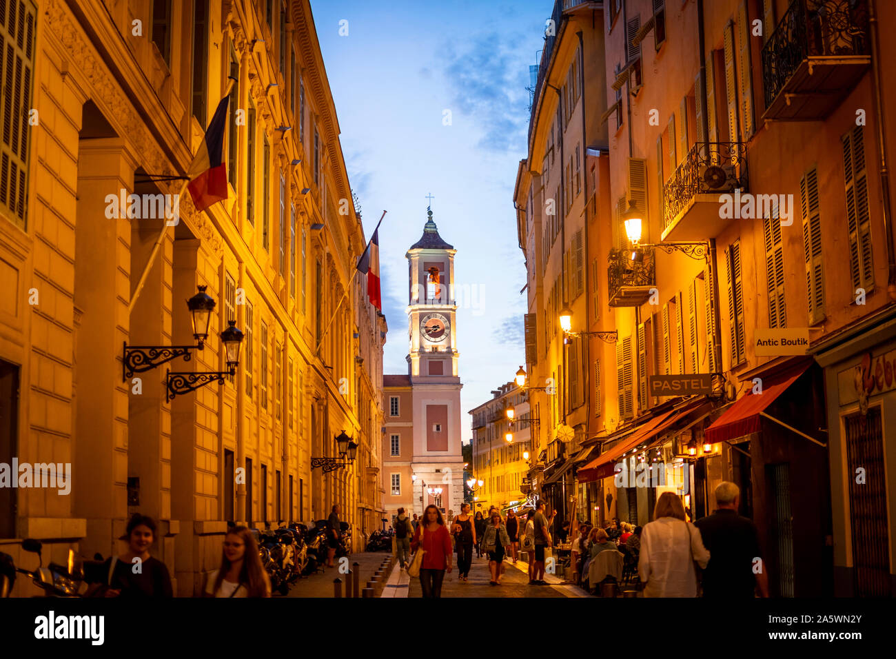 Vista serale del Rusca Palazzo dell'orologio da torre a La Place du Palais du giustizia nella città del Mediterraneo di Nizza, Francia. come turisti godersi la vita notturna Foto Stock