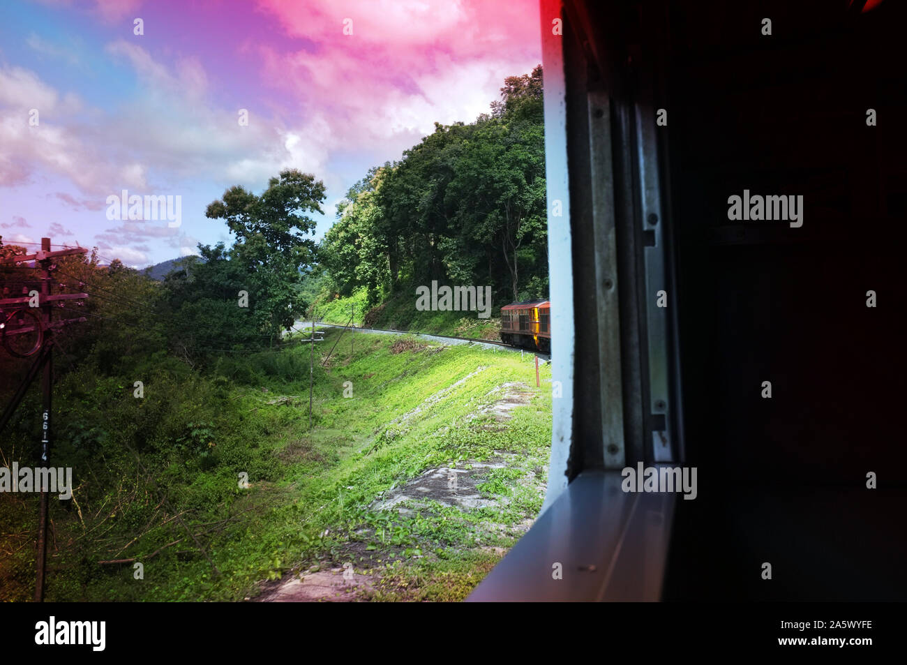 Vista dalla stazione del treno fa una curvatura della curva attraverso le bellezze naturali della verde dei prati e montagne . Viaggi in Thailandia , effetto saturazione Foto Stock