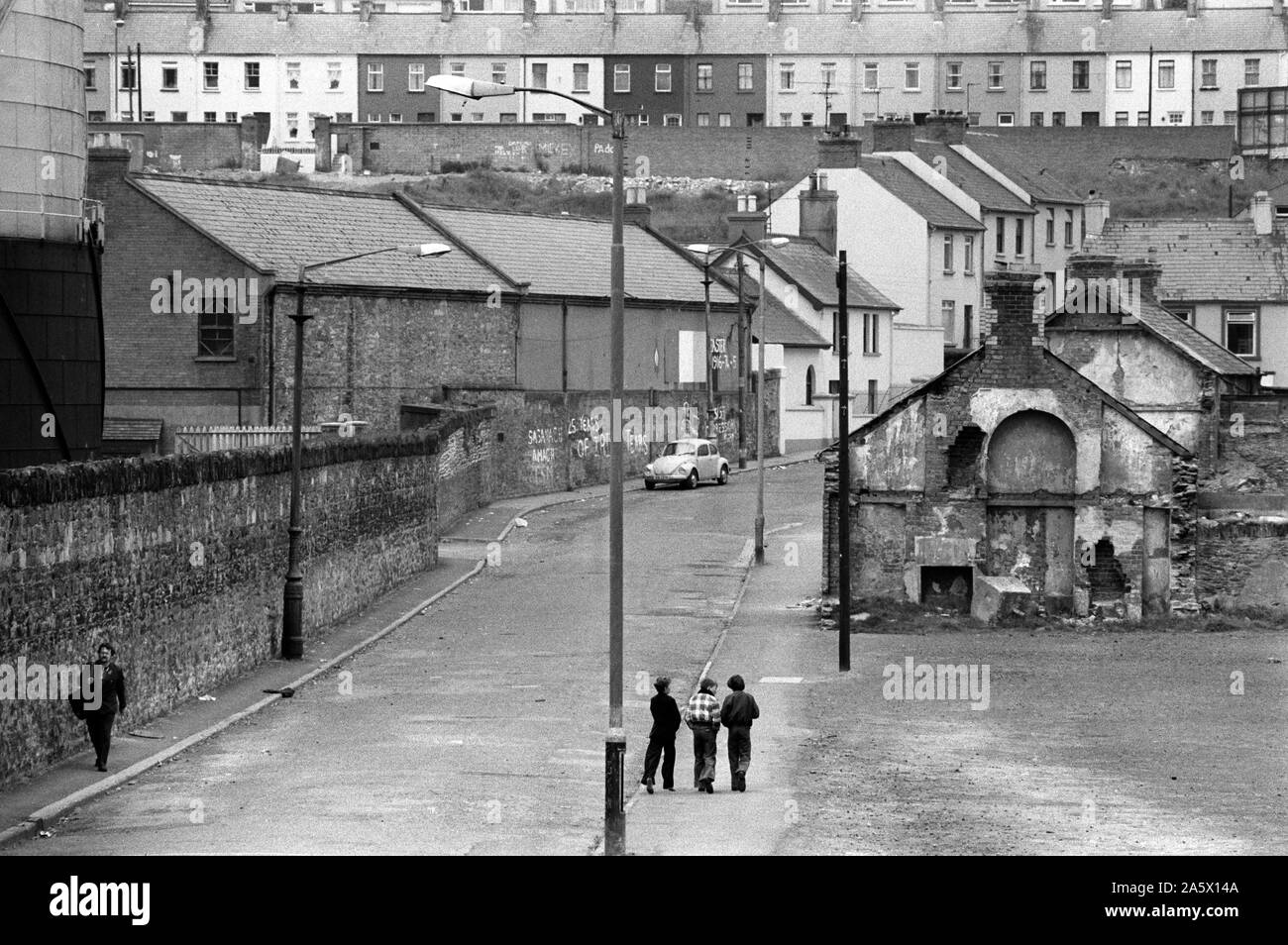 Derry Irlanda del Nord Londonderry. I guai 1979. Zona cattolica di Derry, Tricolore dipinta sulla parete sopra l'auto. Stanleys a piedi nel Bogside con il vecchio Gasyard a sinistra. Anni Settanta HOMER SYKES Foto Stock