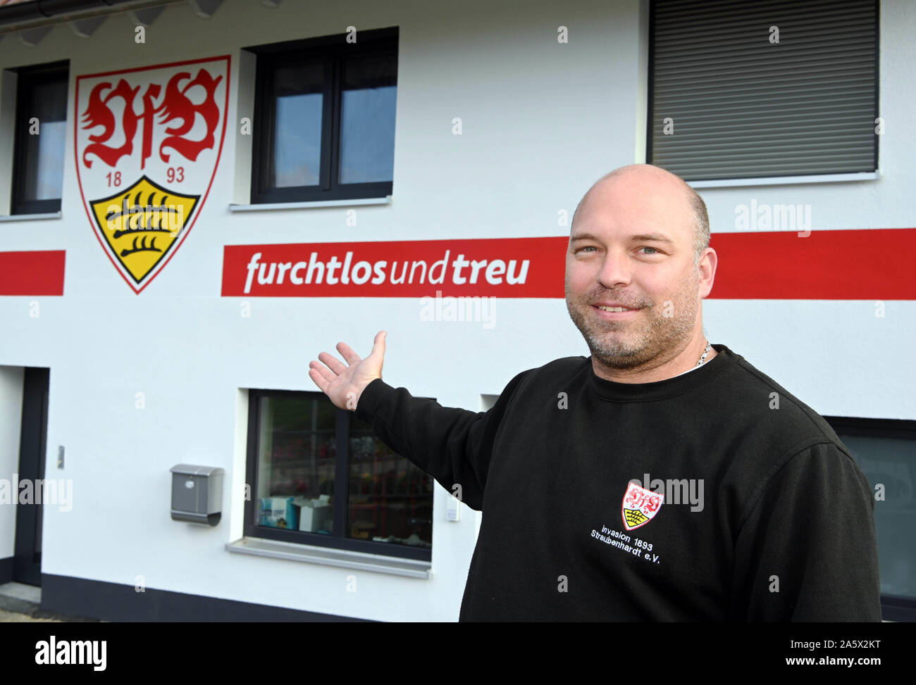 22 ottobre 2019, Baden-Wuerttemberg, Neuenbürg: Michael La Neuweiler sorge nella parte anteriore della sua casa che egli ha verniciato nei colori rosso-bianco e il club stemma della seconda league club VfB Stuttgart. La Neuweiler è stata la ristrutturazione della casa per tre anni dopo che la riprendono da sua nonna. Ora è stata la facciata di turno. La Neuweiler è stato un fan del club di Stoccarda per dieci anni ed è stato anche presidente del VfB fan club 'invasione 1893 Straubenhardt' per un paio di settimane. Foto: Uli Deck/dpa Foto Stock