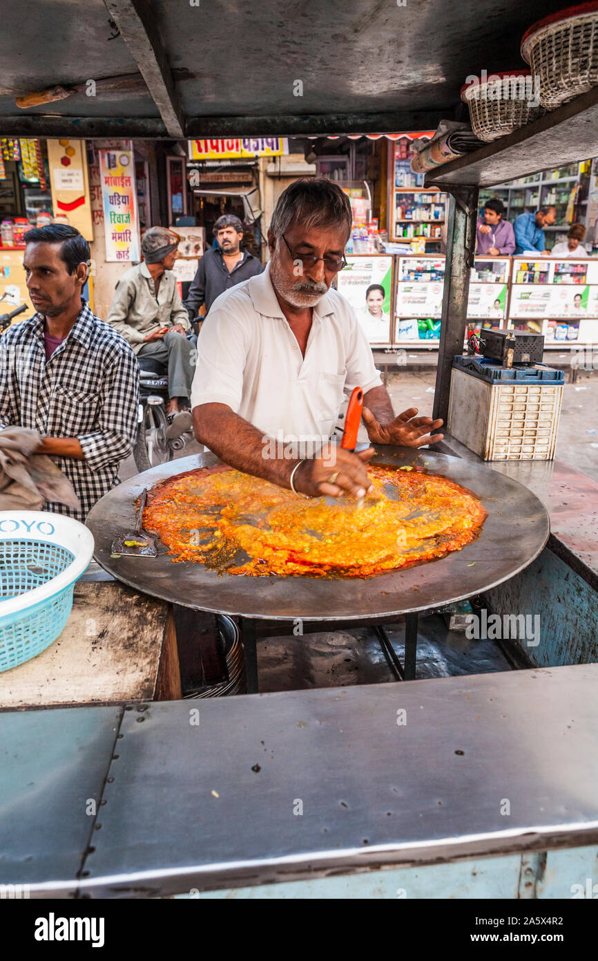 Un uomo la cottura in un mercato all'aperto in Jodhpur, Rajasthan, India. Foto Stock