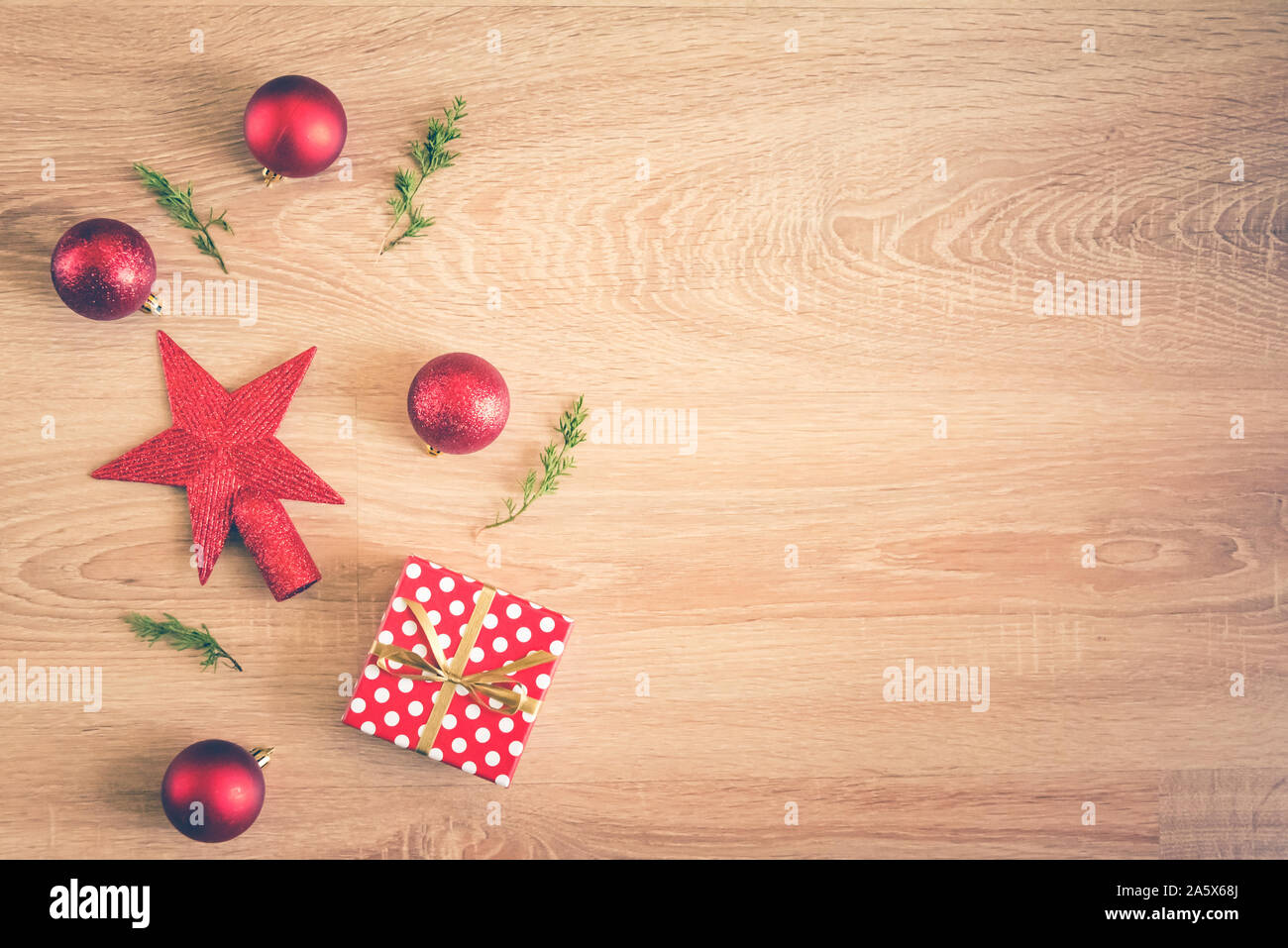 Sfondo di natale - piatto di laici rosso palle di Natale, pigne e una confezione regalo su sfondo di legno. Copia dello spazio. Foto Stock