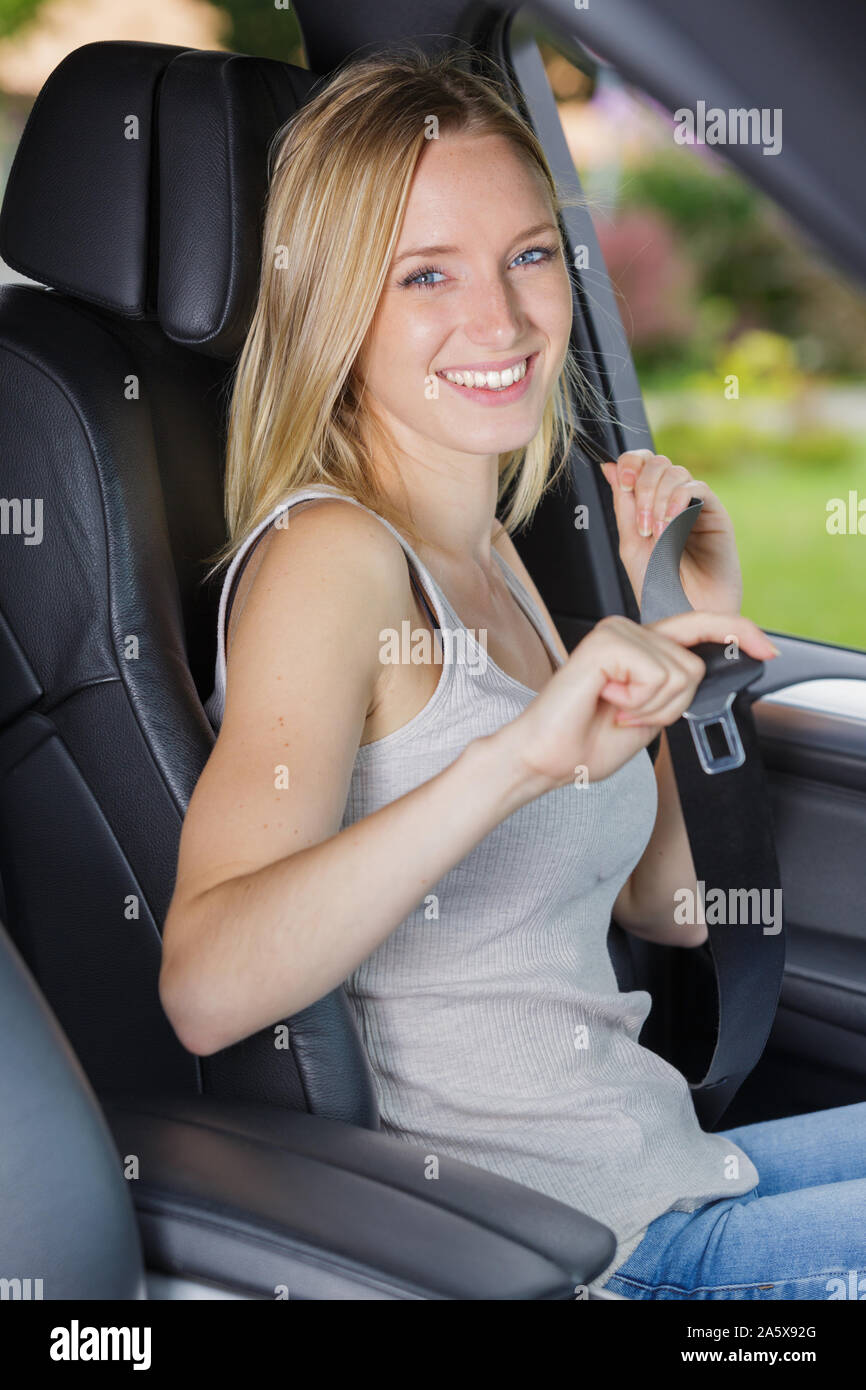 Donna di fissaggio a mano una cintura di sicurezza in auto Foto stock -  Alamy