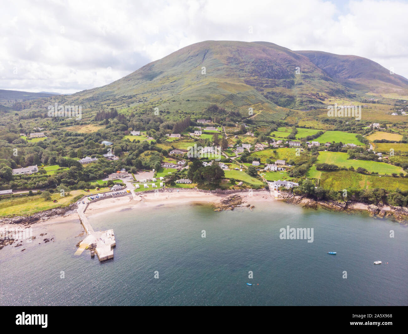 Una veduta aerea di Kells Bay e a Kells Beach, con il suo piccolo porto, sull'anello di Kerry, nella contea di Kerry, Irlanda. Foto Stock
