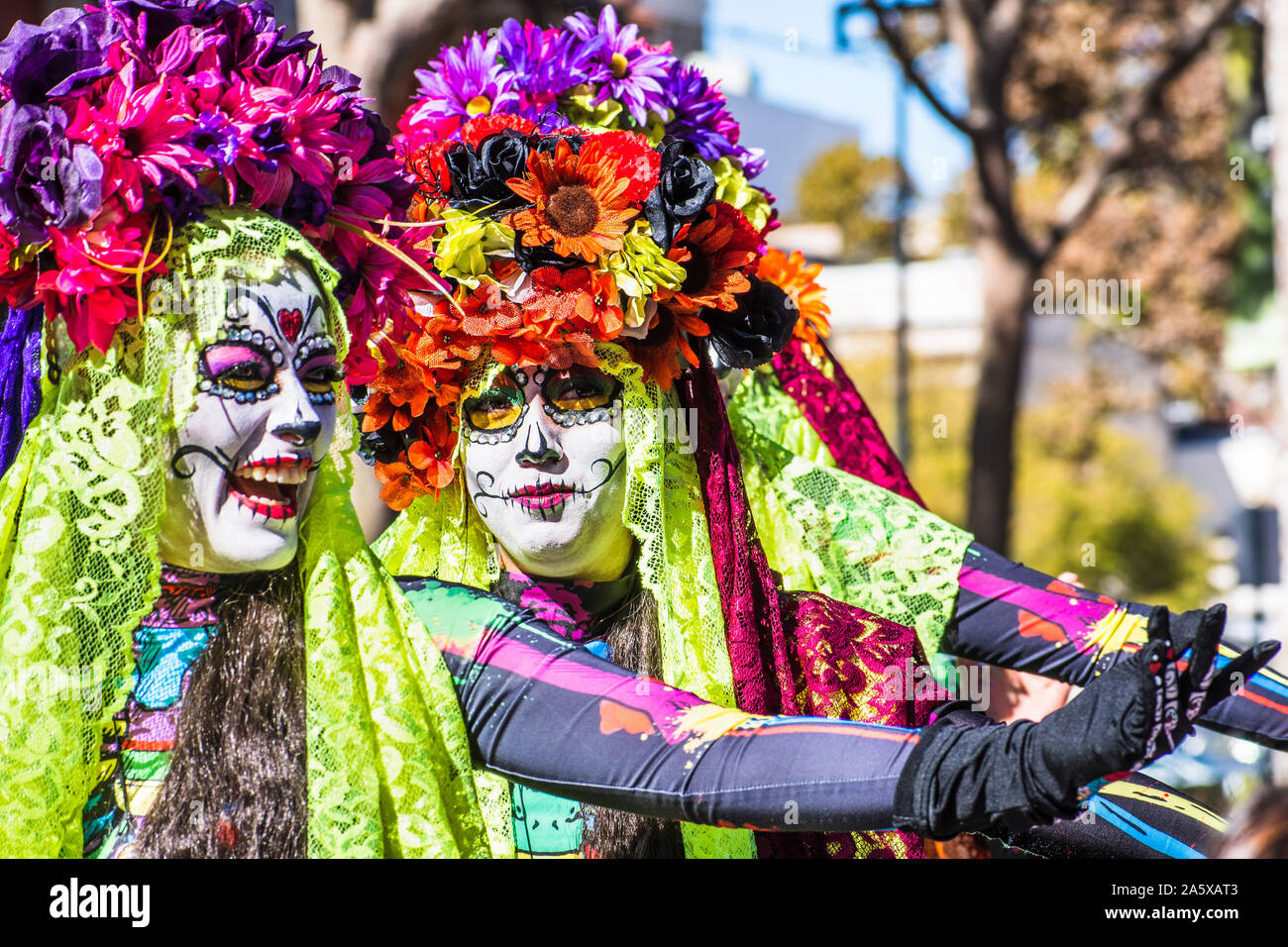 Oct 20, 2019 San Jose / CA / STATI UNITI D'AMERICA - Ritratto di donna con zucchero-cranio make-up, che partecipano al Dia de los Muertos (Giorno dei Morti) processione tenendo Foto Stock