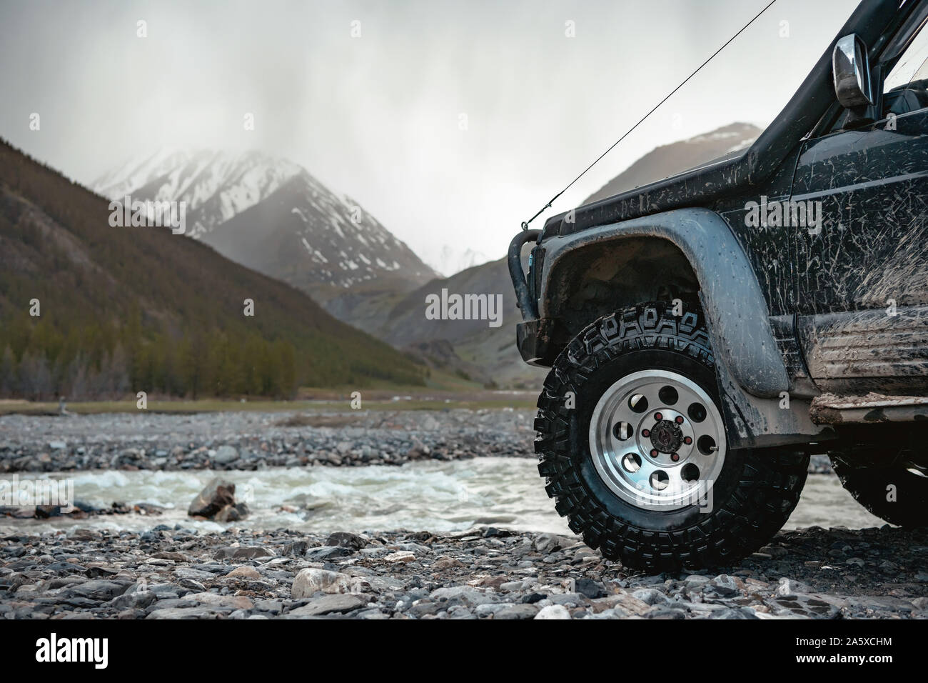 Big extreme offroad pronto auto ruota contro le montagne e il fiume Foto Stock