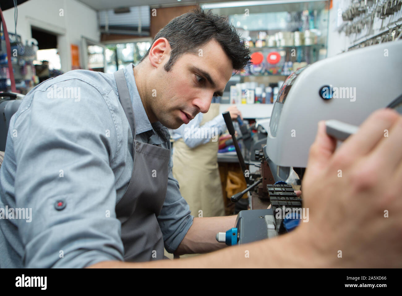 Tuttofare rendendo le chiavi della porta di copie Foto Stock