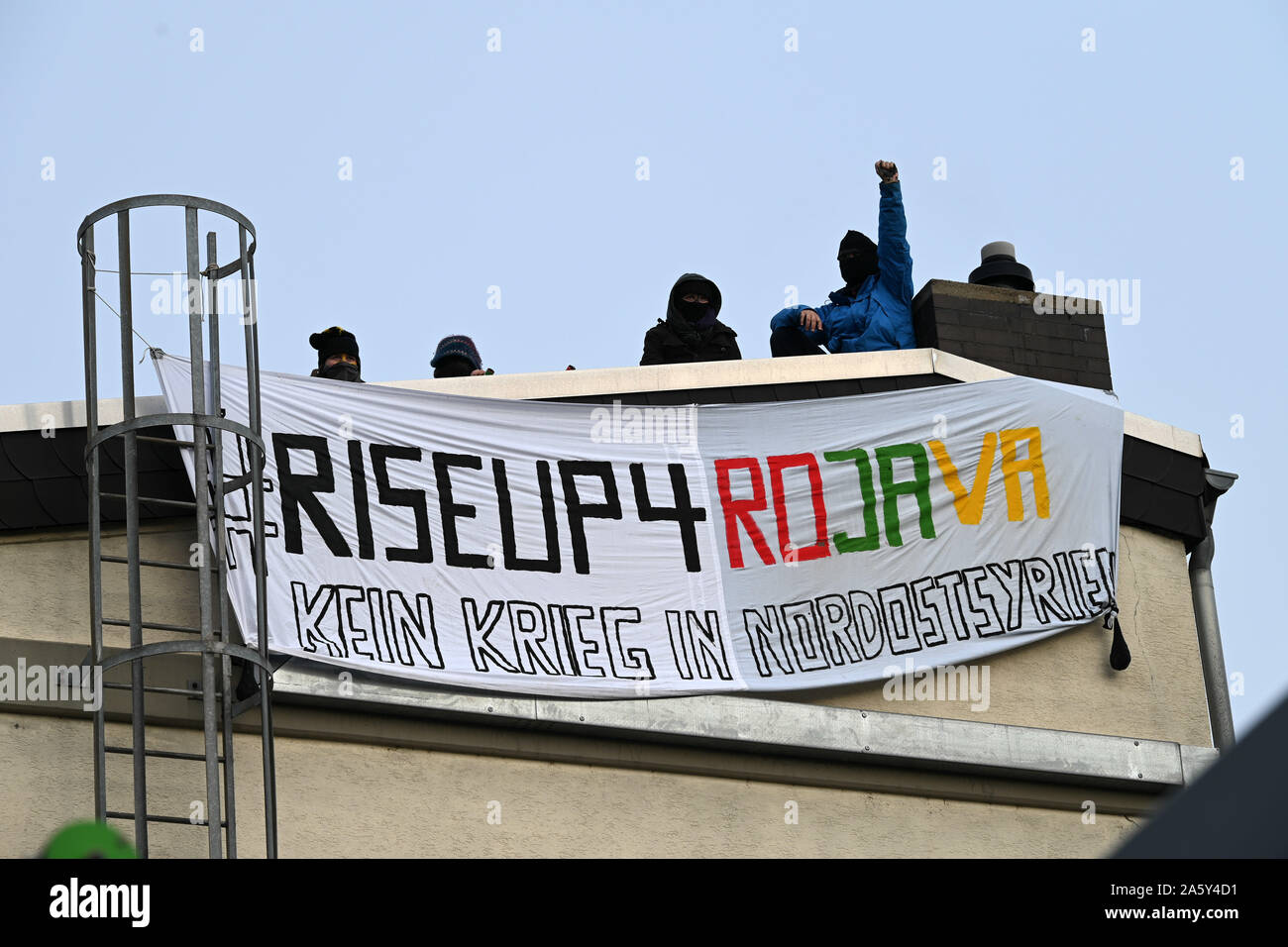Kassel, Germania. 23 Ott, 2019. Gli attivisti del proxy con un banner "Riseup4Rojavy nessuna guerra nel nord-est della Siria' hanno occupato il tetto dei bracci società Krauss-Maffei Wegmann per protestare contro i Turchi offensiva militare nella Siria settentrionale e il tedesco forniture di armi alla Turchia. Credito: Uwe Zucchi/dpa/Alamy Live News Foto Stock