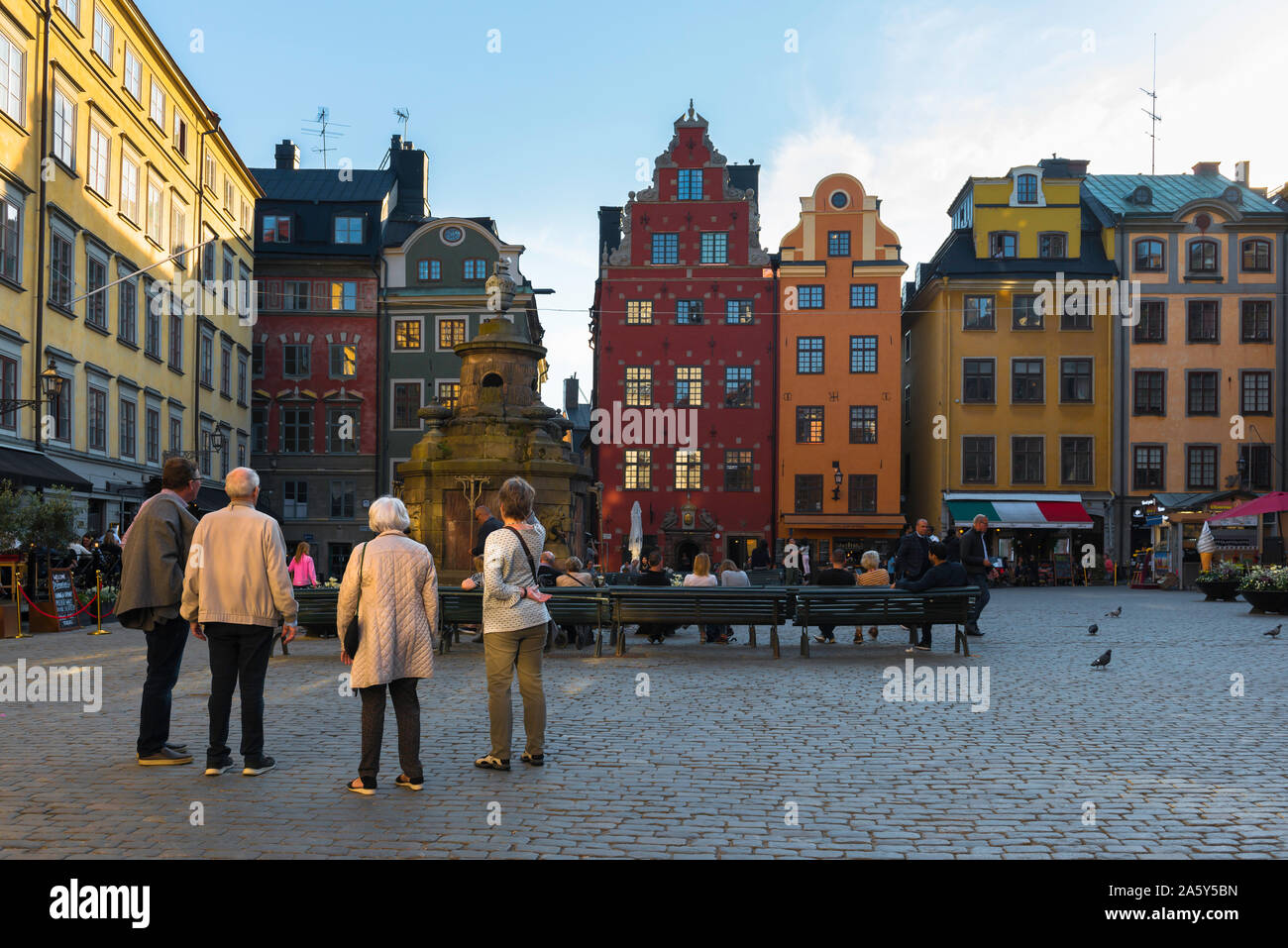 Persone mature viaggi, vista di senior amici guardando gli edifici colorati in piazza del Mercato della Città Vecchia (Gamla Stan), Svezia Foto Stock