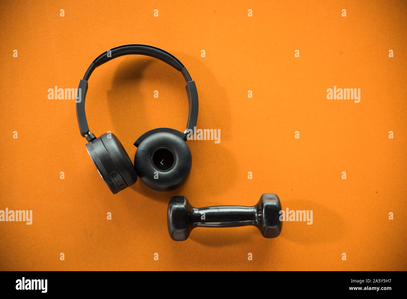 Cuffie per musica e un manubrio su orange pavimento in gomma in palestra per  il fitness Foto stock - Alamy