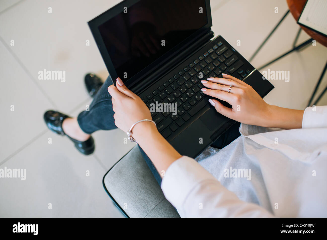 Giovane imprenditrice seduto alla scrivania, lavorando con il computer portatile. Tastiera vista dall'alto. Ottenere pronto per tipo. Foto Stock