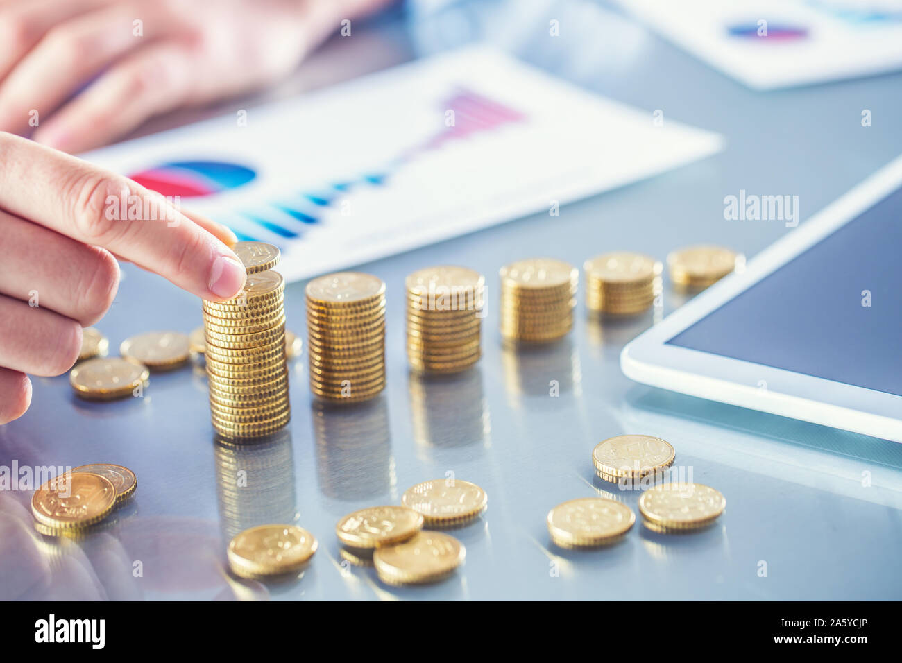 Banchiere commercialista o assicuratore costruisce grafico finanziario da monete d oro Foto Stock