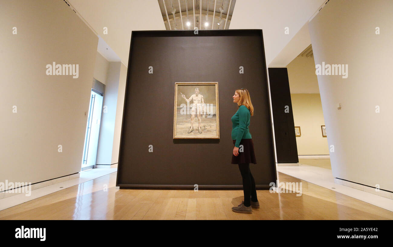 Una galleria dipendente guarda al pittore lavorando, riflessione di Lucian Freud durante un'anteprima di Lucian Freud: il Self-ritratti mostra presso il Jillian e Arthur M. Sackler Ala di gallerie, Royal Academy of Arts di Londra. Foto Stock