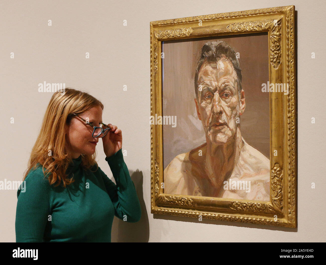 Una galleria dipendente guarda alla riflessione, Autoritratto di Lucian Freud durante un'anteprima di Lucian Freud: il Self-ritratti mostra presso il Jillian e Arthur M. Sackler Ala di gallerie, Royal Academy of Arts di Londra. Foto Stock