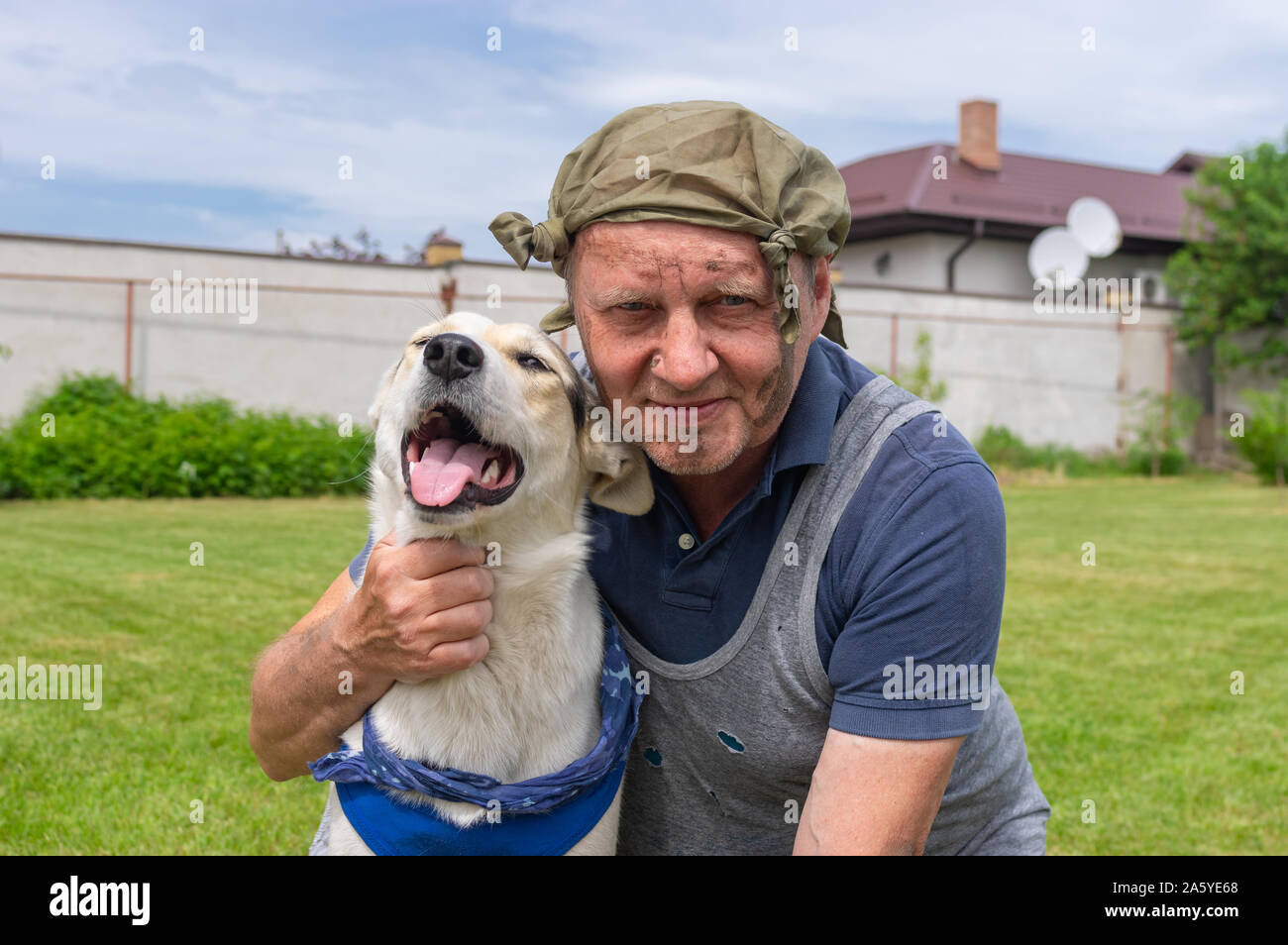 Outdoor ritratto di due senzatetto fiends - dirty uomo maturo e carino di razza cane che entrambi sono felice Foto Stock