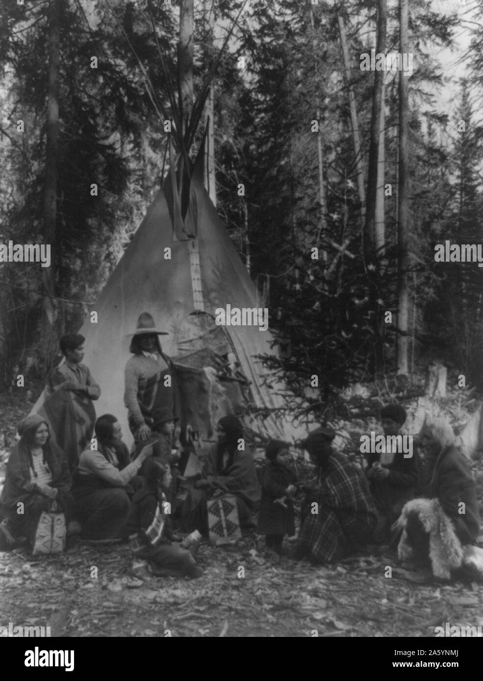 Gli Indiani di Flathead tenendo pre-natale incontri di famiglia sul lato ovest del Parco Nazionale di Glacier, nella fitta foresta di alberi sempreverdi che costeggiano le montagne rocciose [tra il 1900 e il 1920] Foto Stock