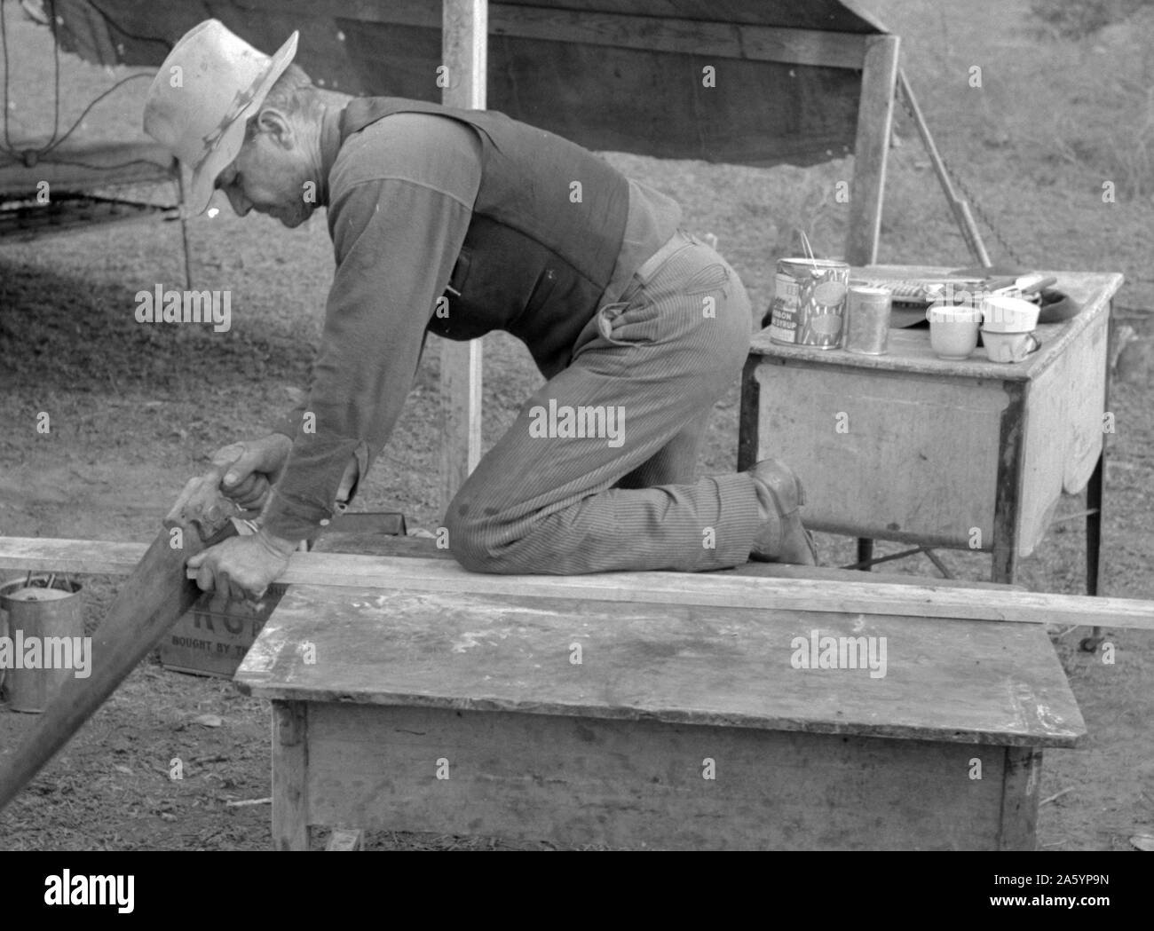 Bianco lavoratore migrante segatura di legno per pali per essere utilizzati nell'impostazione tenda home, vicino a Harlingen, Texas da Russell Lee, 1903-1986, datata 19390101. Foto Stock