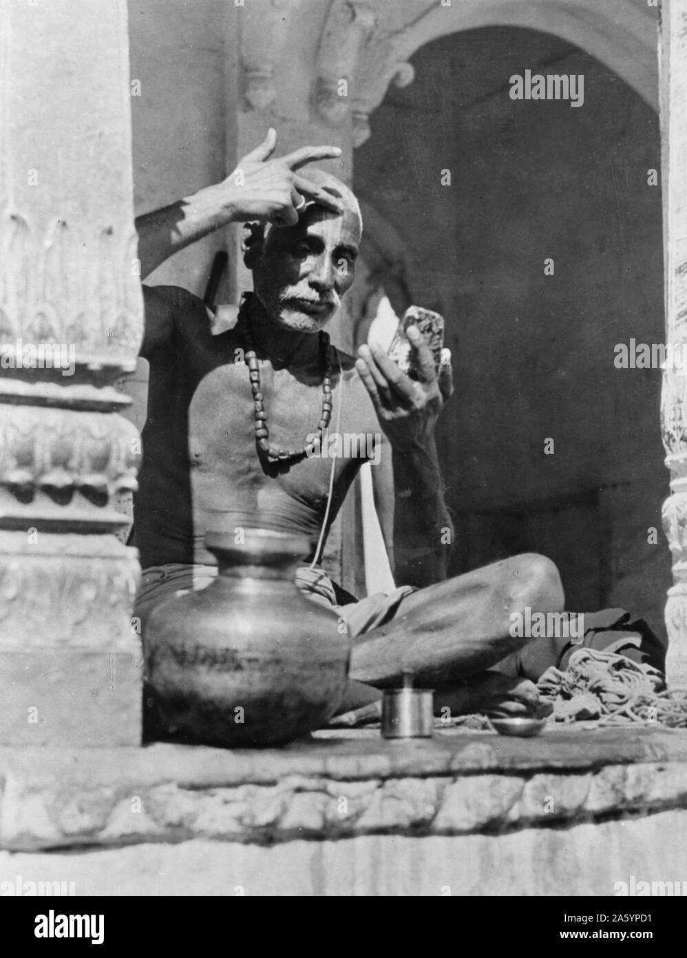 Stampa fotografica di un sacerdote Brahman in India la pittura la sua fronte con il rosso e bianco della setta e casta. Datata 1920 Foto Stock