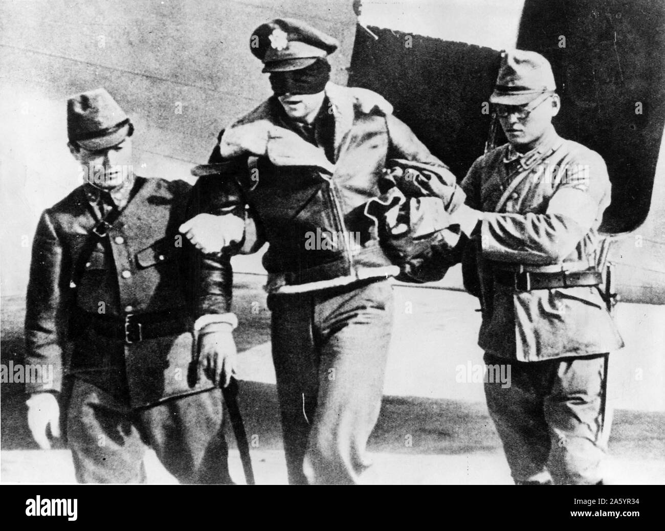 La seconda guerra mondiale: catturato e gli occhi bendati pilota della US Air Force, con due soldati giapponesi. Acquisite durante la durante la Doolittle raid aerei su Tokyo. 1942 Foto Stock