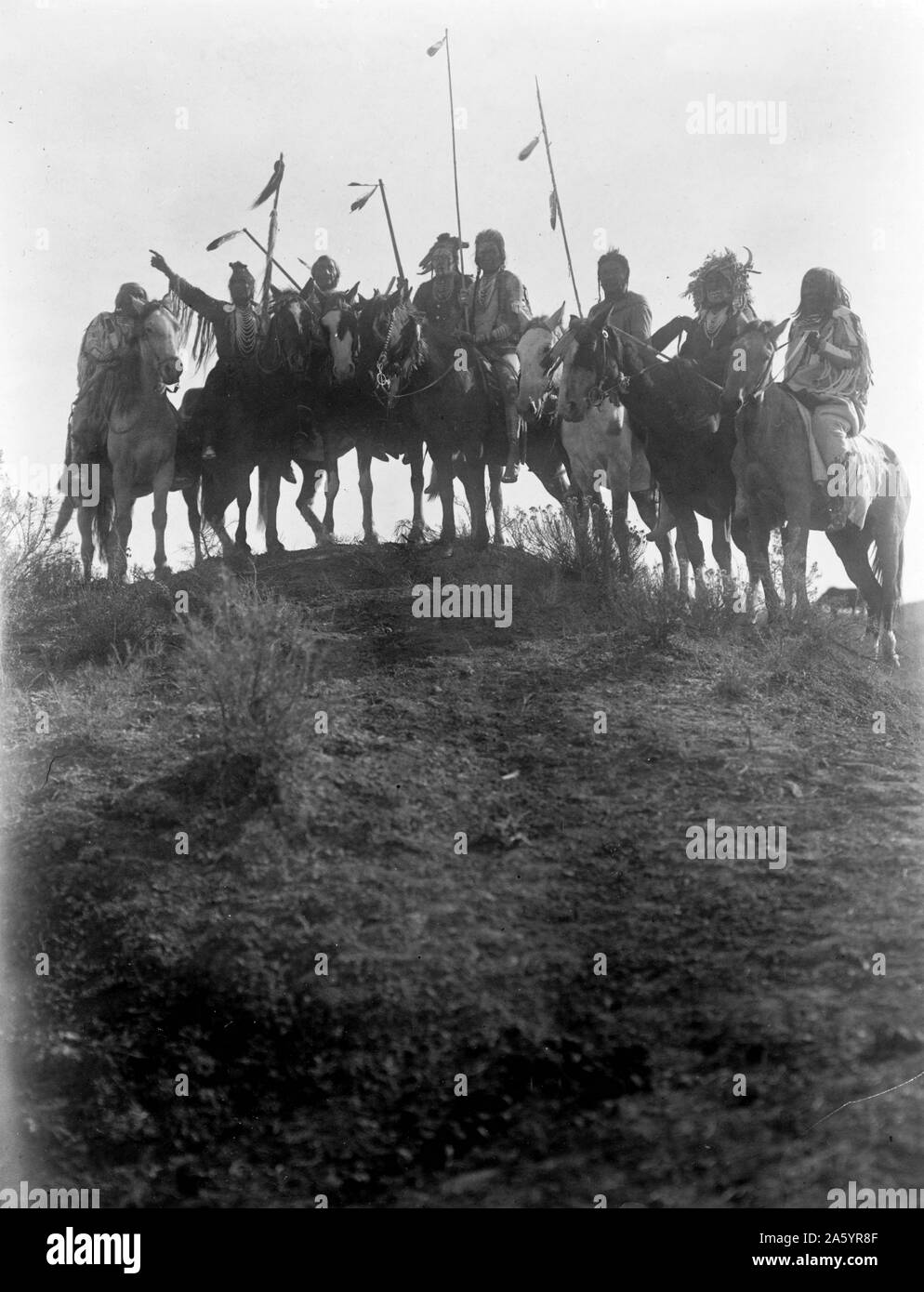 Stampa fotografica di otto Crow indiani a cavallo, stagliano sulla cima della collina. Fotografata da Edward S. Curtis (1868-1952) American etnologo e fotografo del West americano e dei Nativi Americani i popoli. Datata 1908 Foto Stock