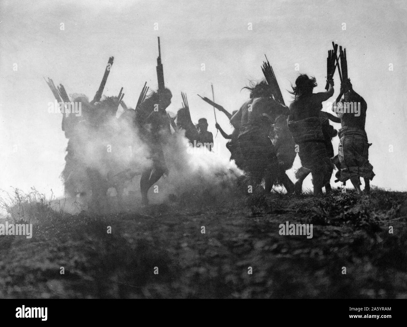 Stampa fotografica di persone il Kwakiutl (Kwakwaka'wakw, Indiani del Nord America) eseguendo una danza rituale per ripristinare un Luna eclissata. Fotografata da Edward S. Curtis (1868-1952) American etnologo e fotografo del West americano e dei Nativi Americani i popoli. Datata 1914 Foto Stock