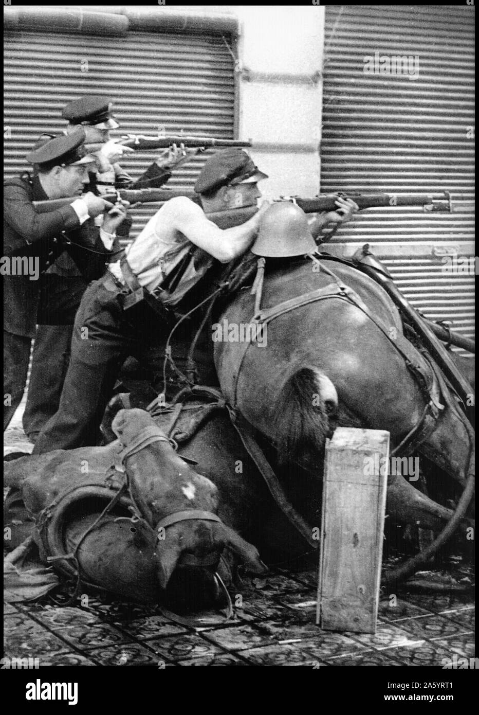 Il repubblicano fighters prendano di mira dietro una barricata di un cavallo morto in una strada di Barcellona 1937, durante la guerra civile spagnola Foto Stock