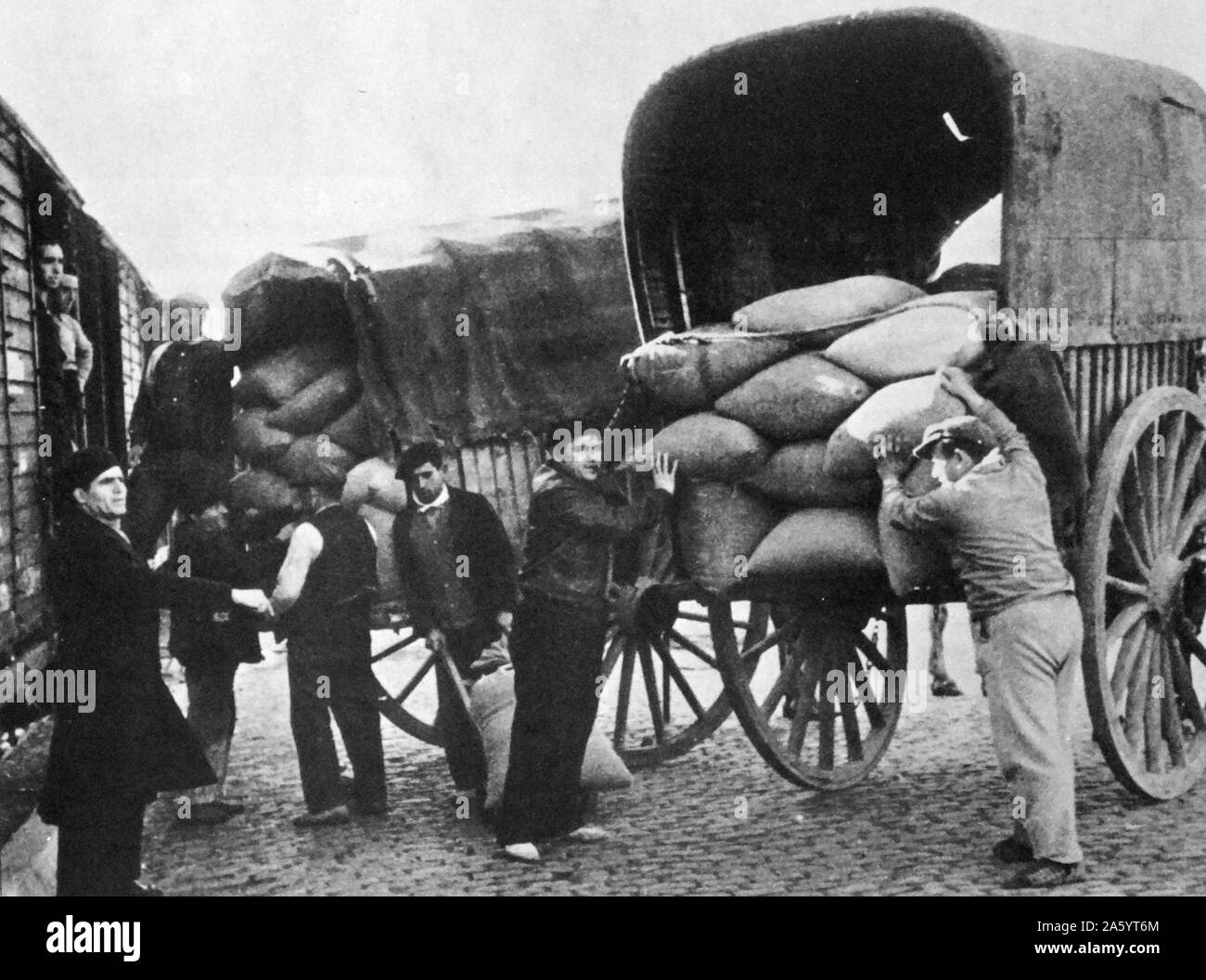 Forniture di cereali sono trasferiti da carri a carrelli ferroviari per la distribuzione durante la Guerra Civile Spagnola 1936 Foto Stock